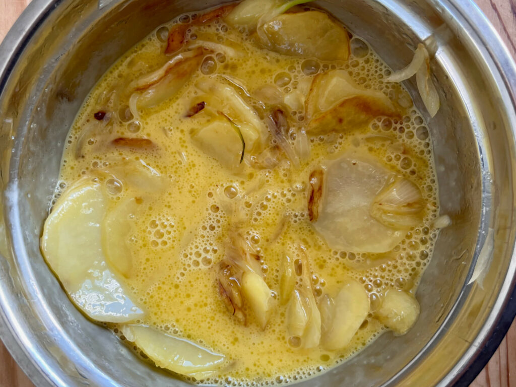 Kartoffeln, Ei und Zwiebeln für die Tortilla de Patatas mischen